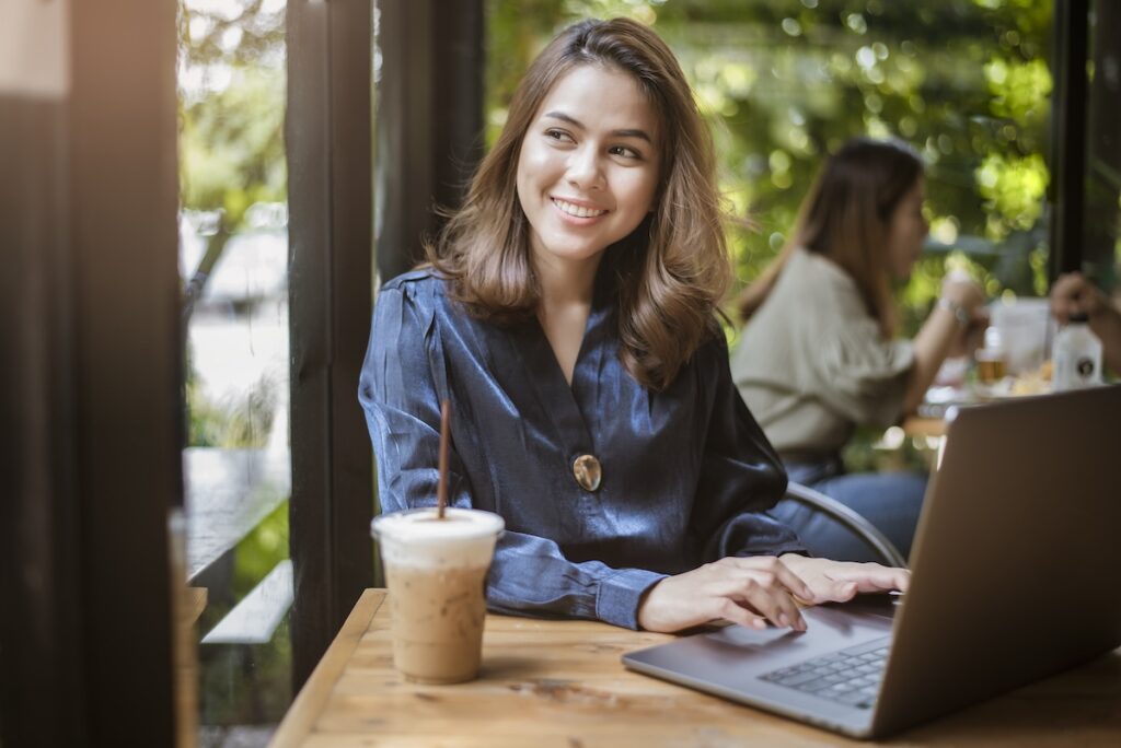 woman works on laptop at a cafe