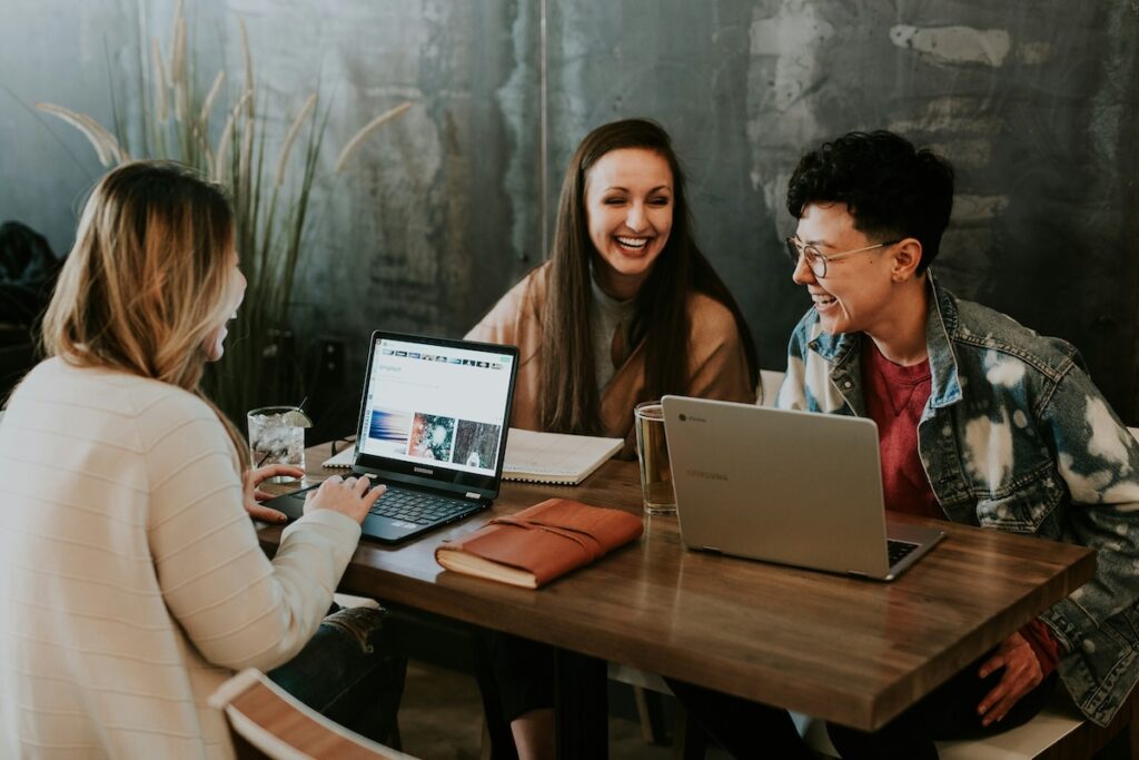 students chat over laptops in a coffee shop