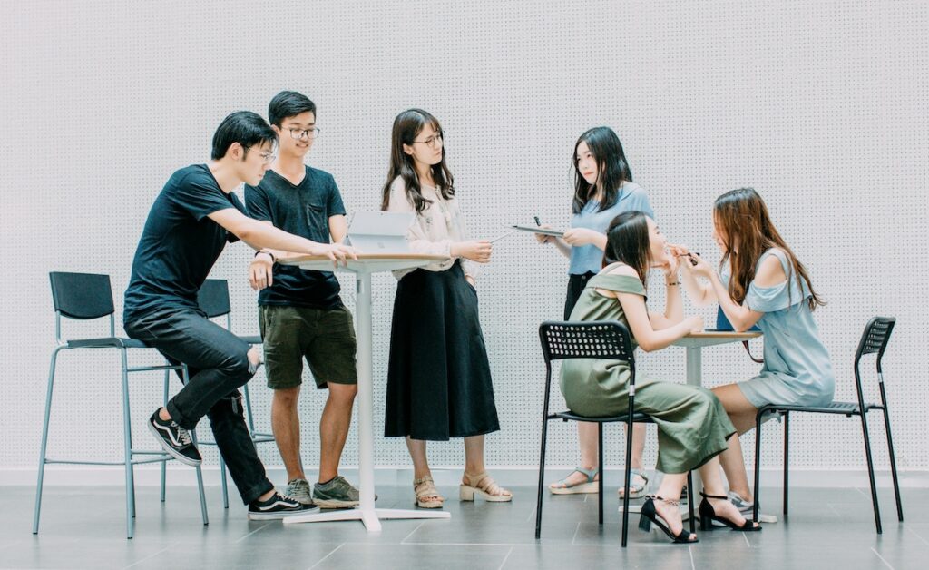 students gathering around two tables in a study group