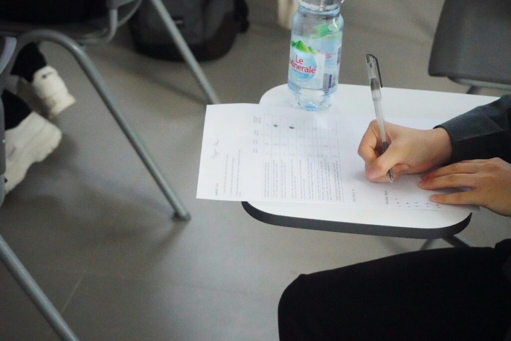 person takes an exam in a student desk