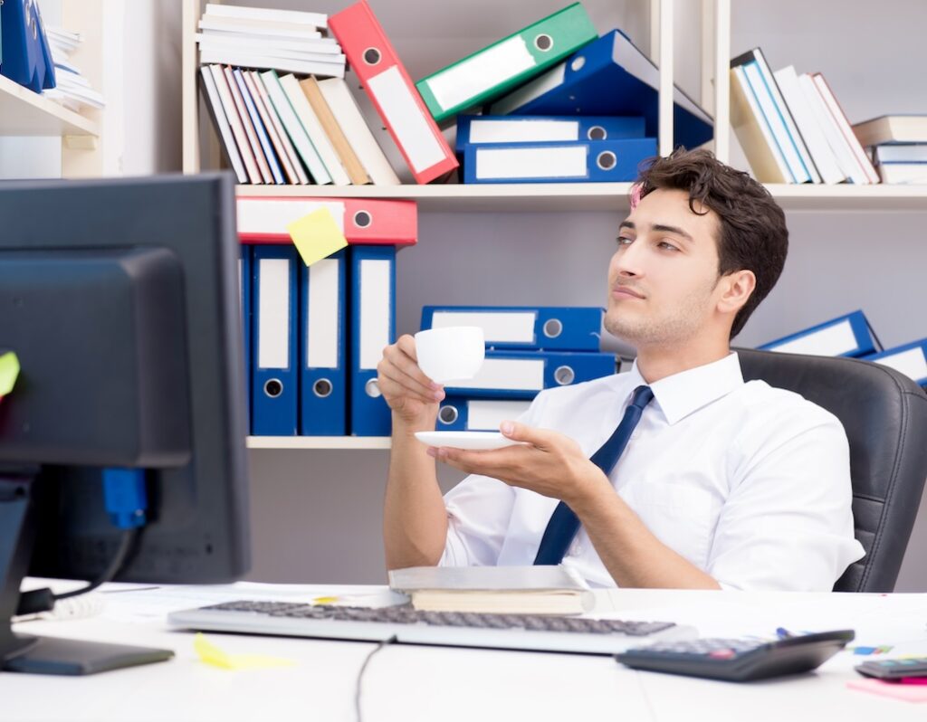 man working in cluttered cubicle