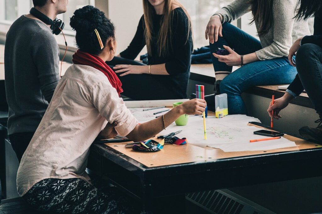 group of students sit around a table and work collaboratively