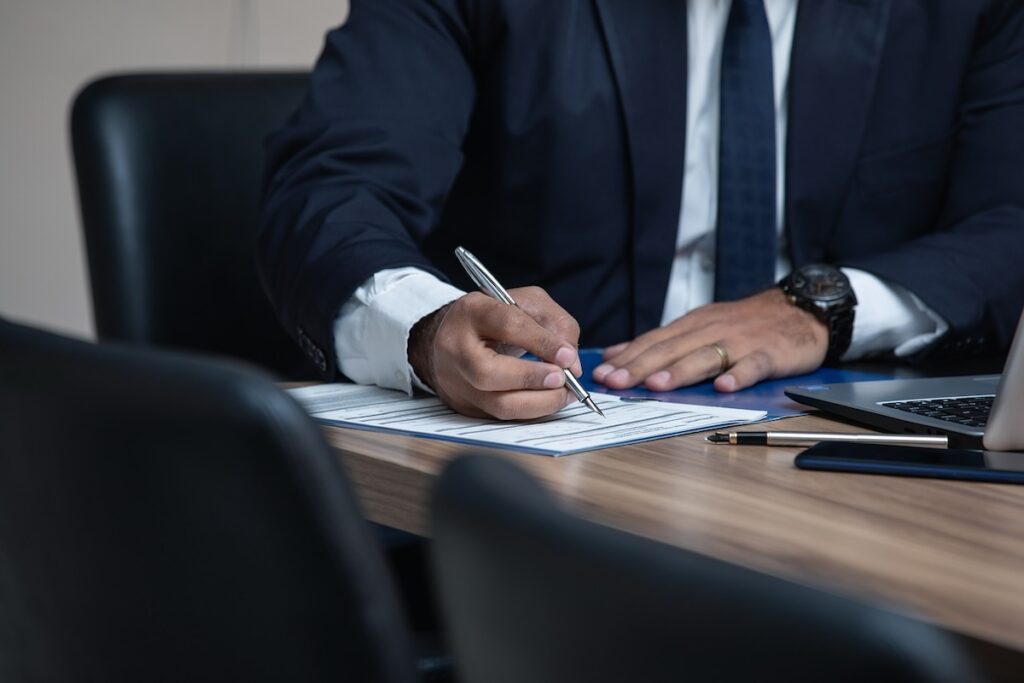 close up of a man's hands filling out paperwork