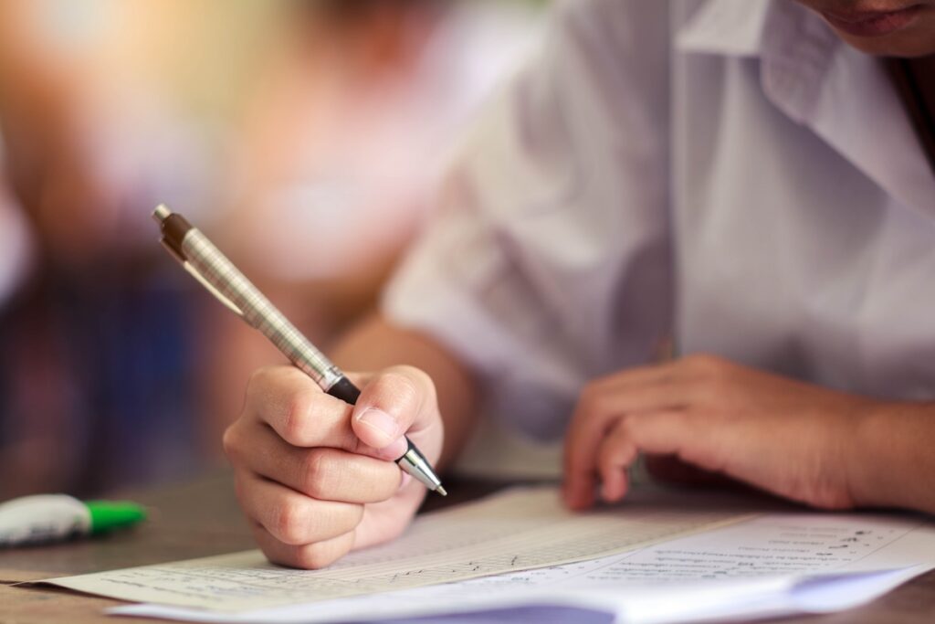 person taking a test with a pen and paper