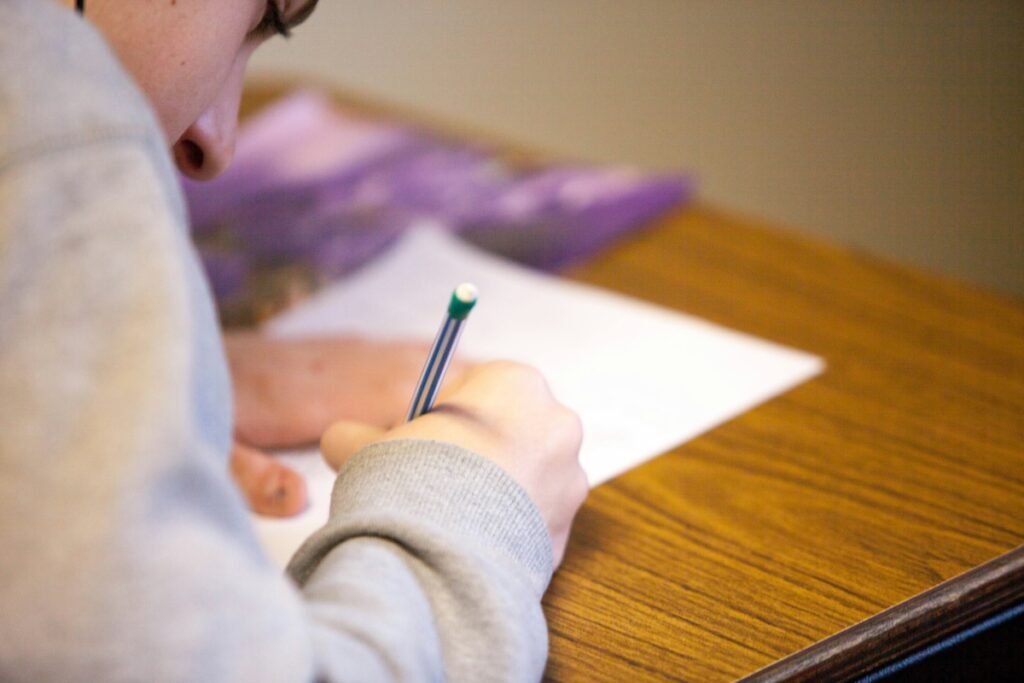 student pouring over paper with pen in hand