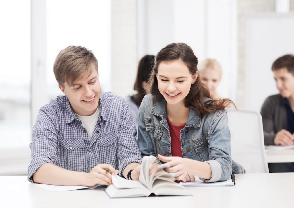 two students study an SAT prep textbook