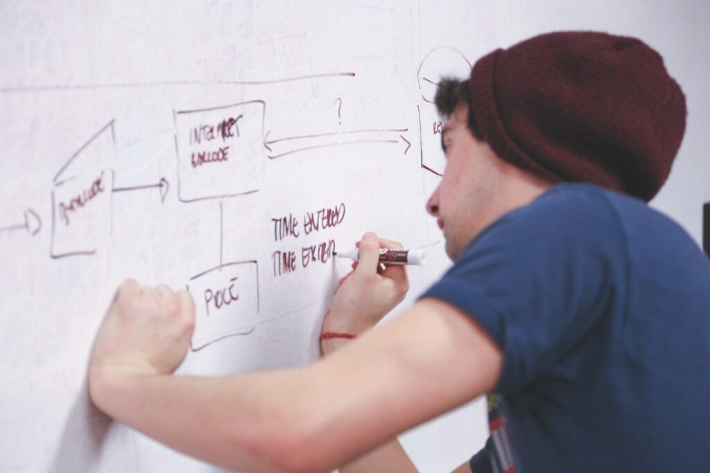 young man writes on whiteboard