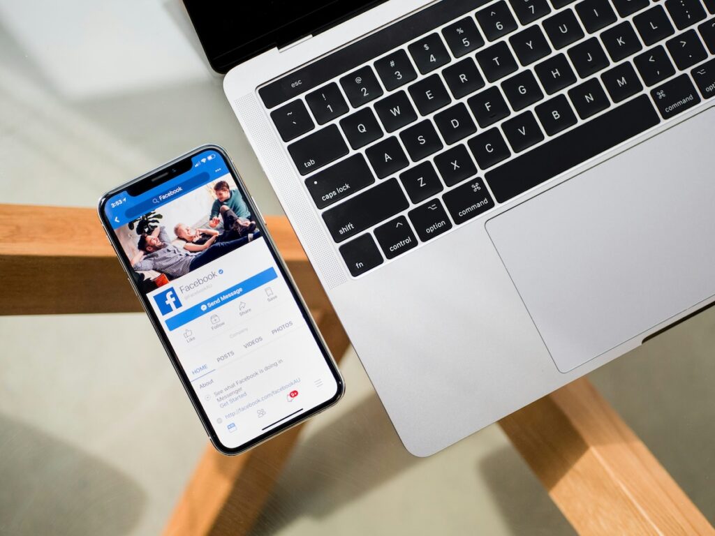 laptop next to an iphone displaying facebook page