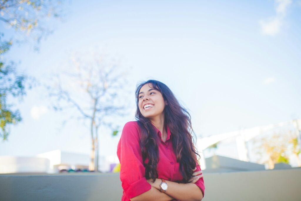 happy woman in red shirt looks toward the sky