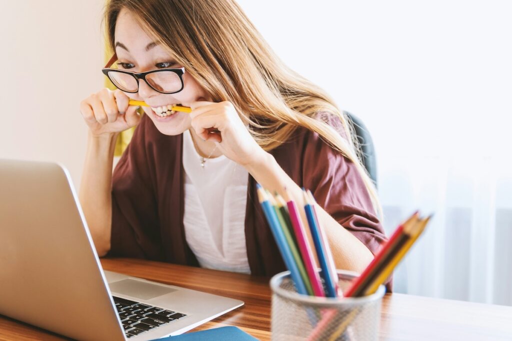 stressed woman biting pencil while working on college application