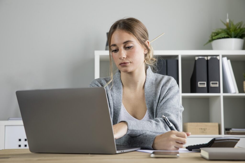 medium shot woman working laptop