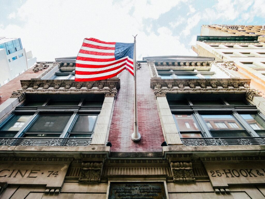 US Flag waving in front of historic-looking building