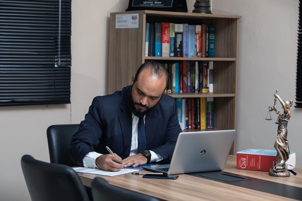 man in a law office writes on a notepad