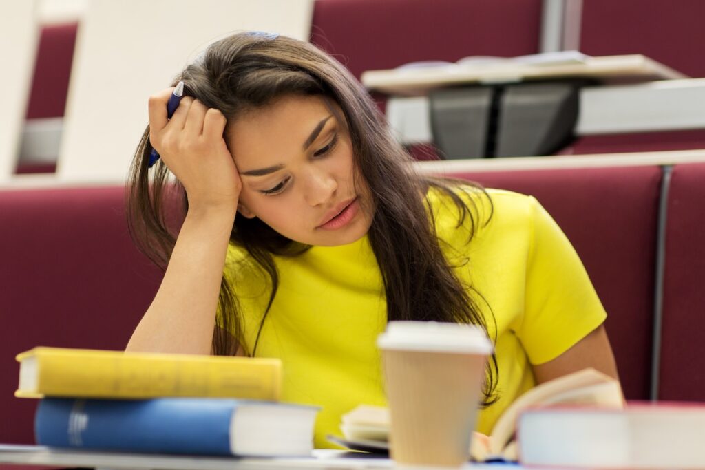 student girl with books and coffee on lecture