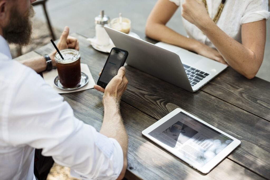 two startup employees work opposite one another at a coffee shop