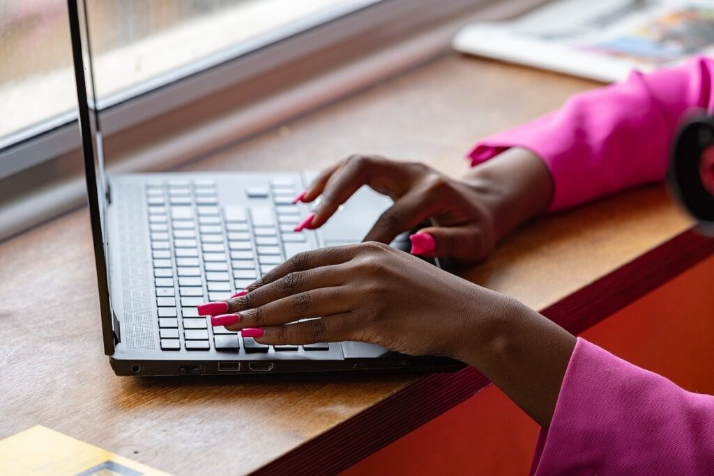 close up of a woman's hands typing on a laptop