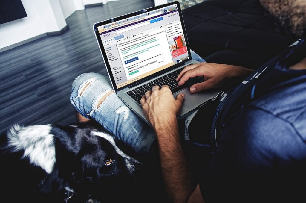 looking over the shoulder of a man writing an email on his laptop