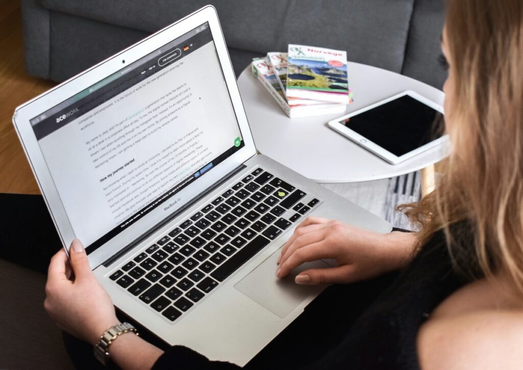 looking over the shoulder of a woman working on her laptop