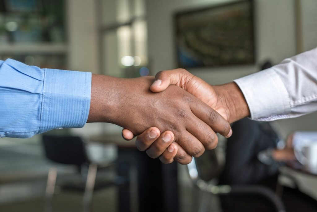 two men shake hands
