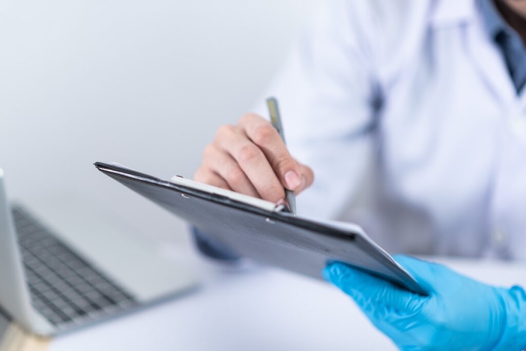 doctor writes something on an ipad