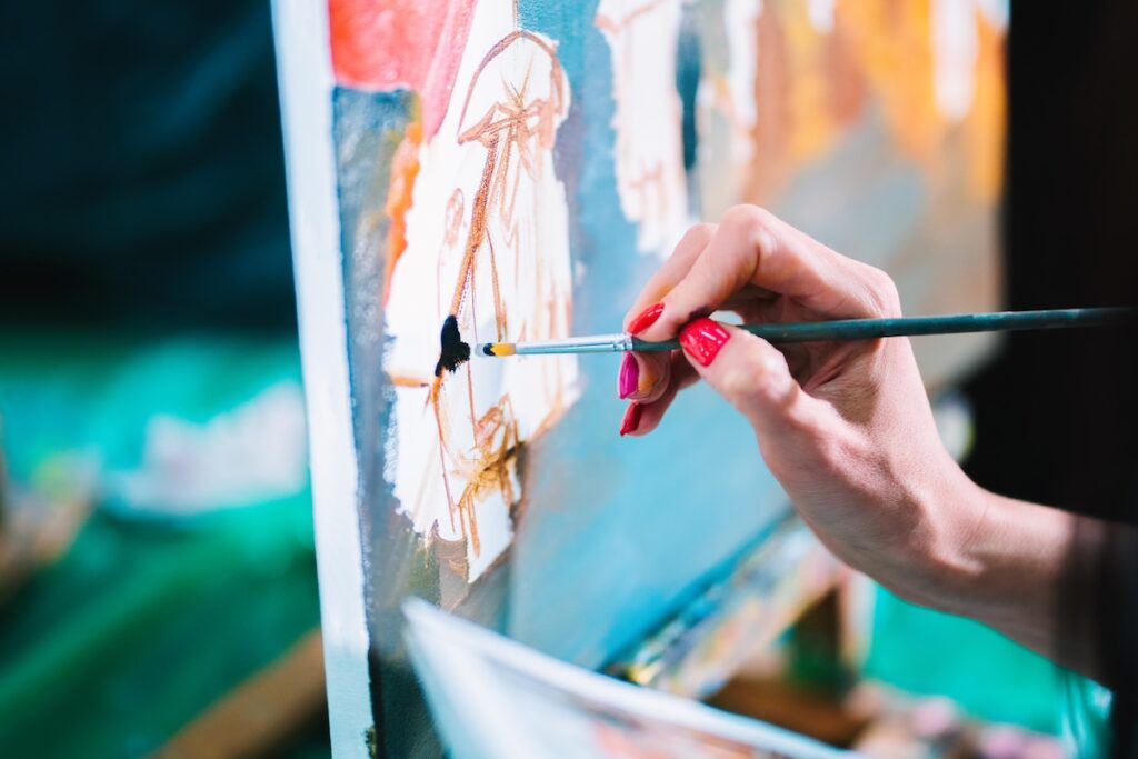 Woman paints a painting on canvas.