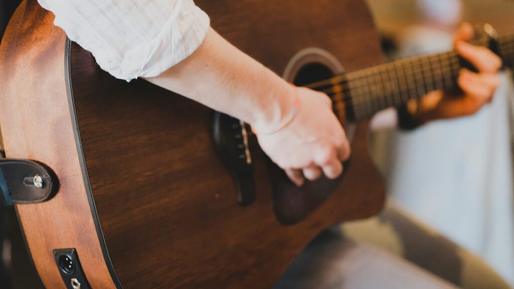 person playing acoustic guitar