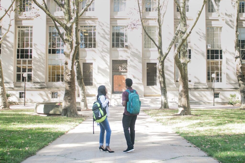 two prospective college students tour a college campus