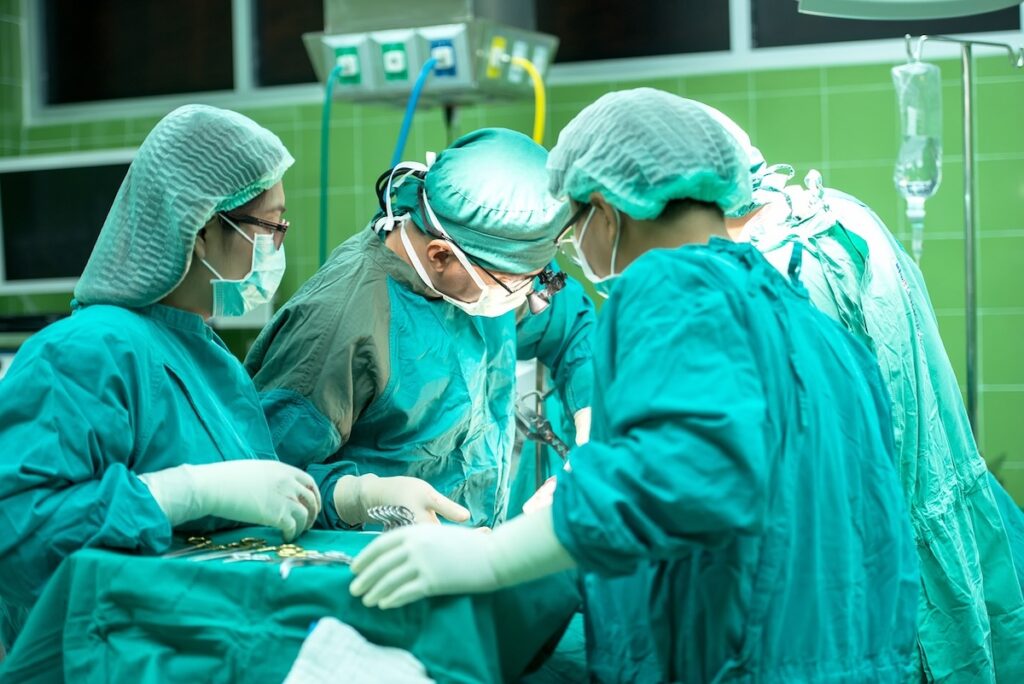 surgeons in full scrubs at work in operating room