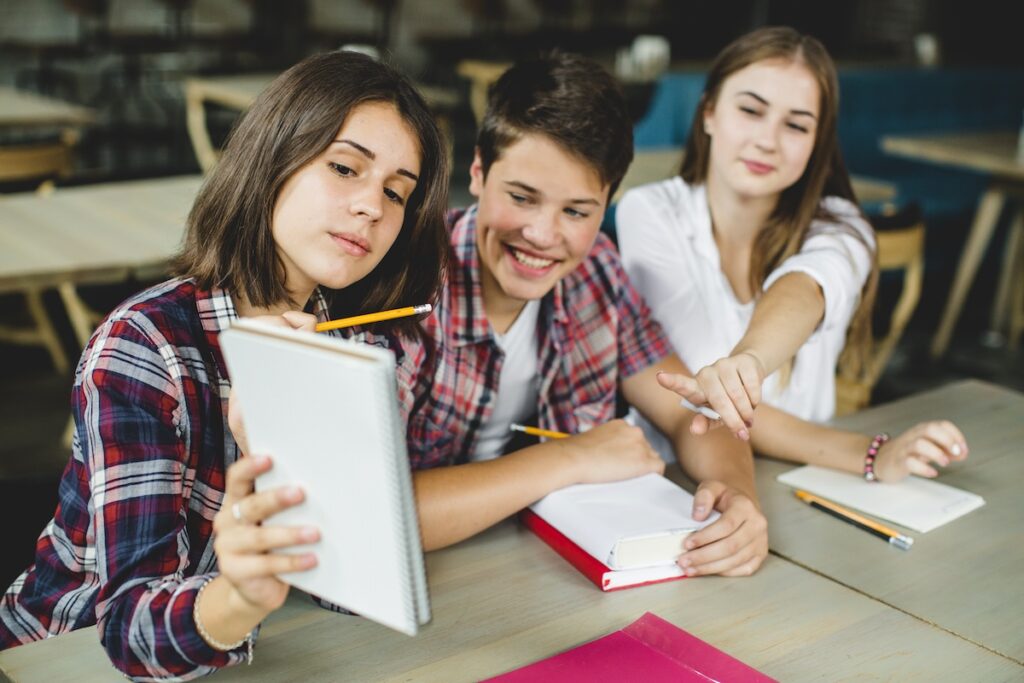 cheerful students hanging out in the classroom