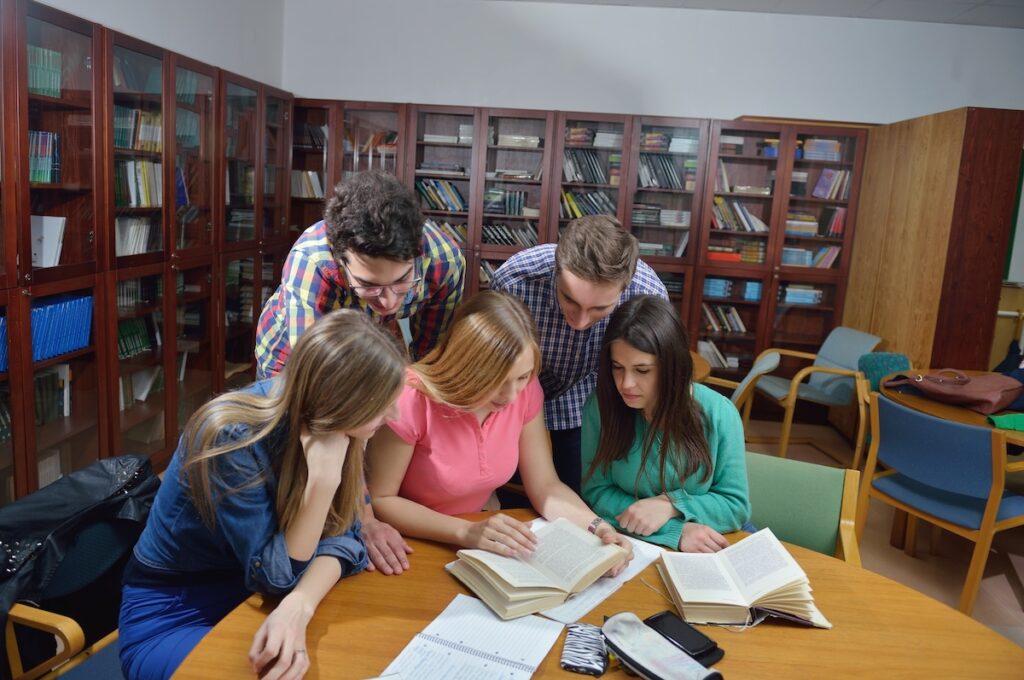 students gathered around a table, studying