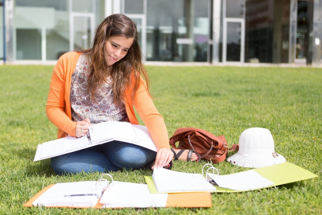 high school student studies on the lawn