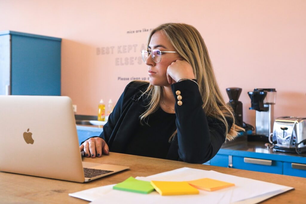 woman studies at her laptop in a pink room