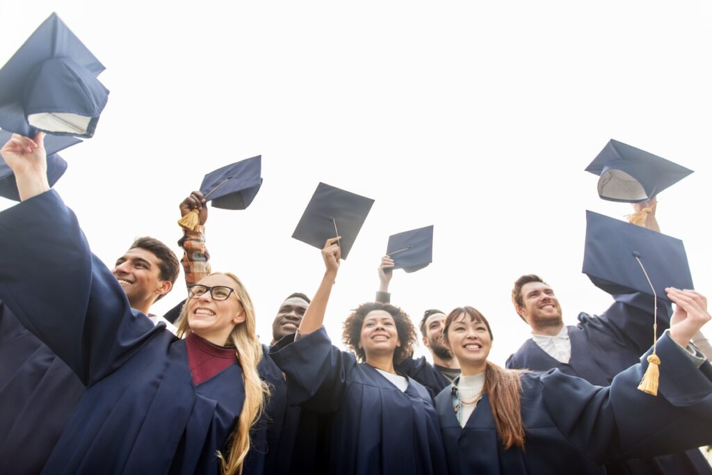 happy graduates in caps and gowns
