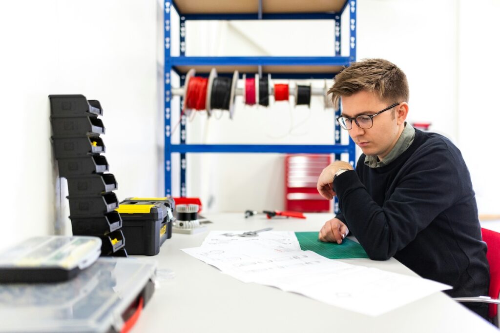 man examines engineering schematics