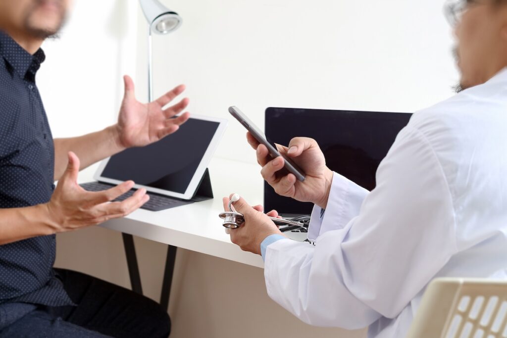 doctor discusses something with a colleague in an office