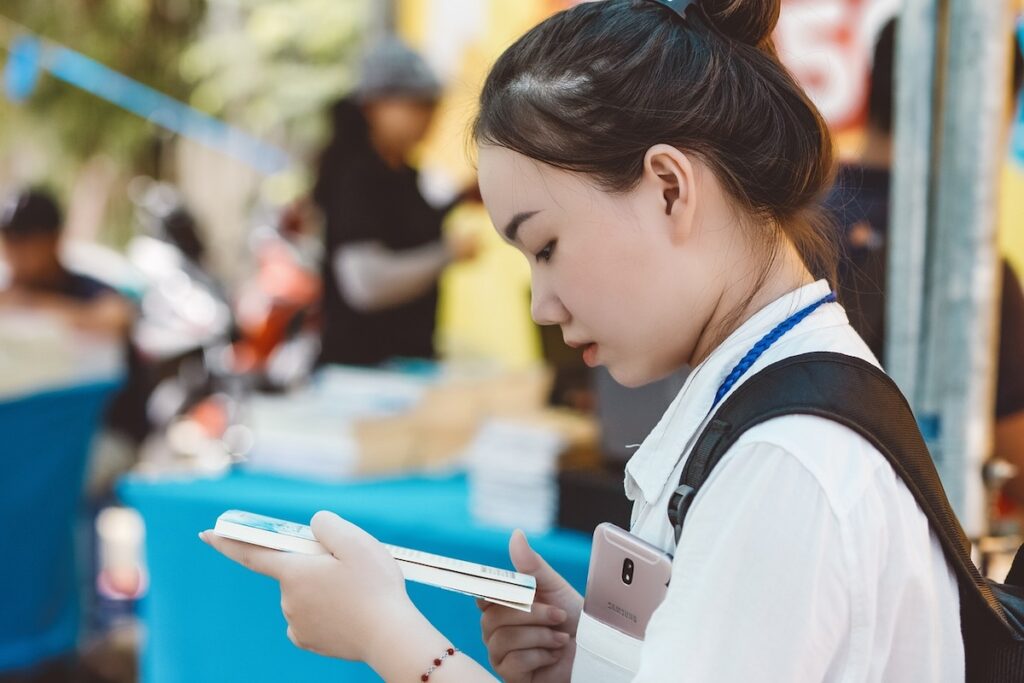 young woman reads a book in a public place