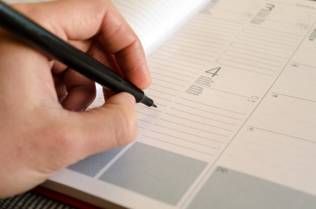 person writing on blank calendar page