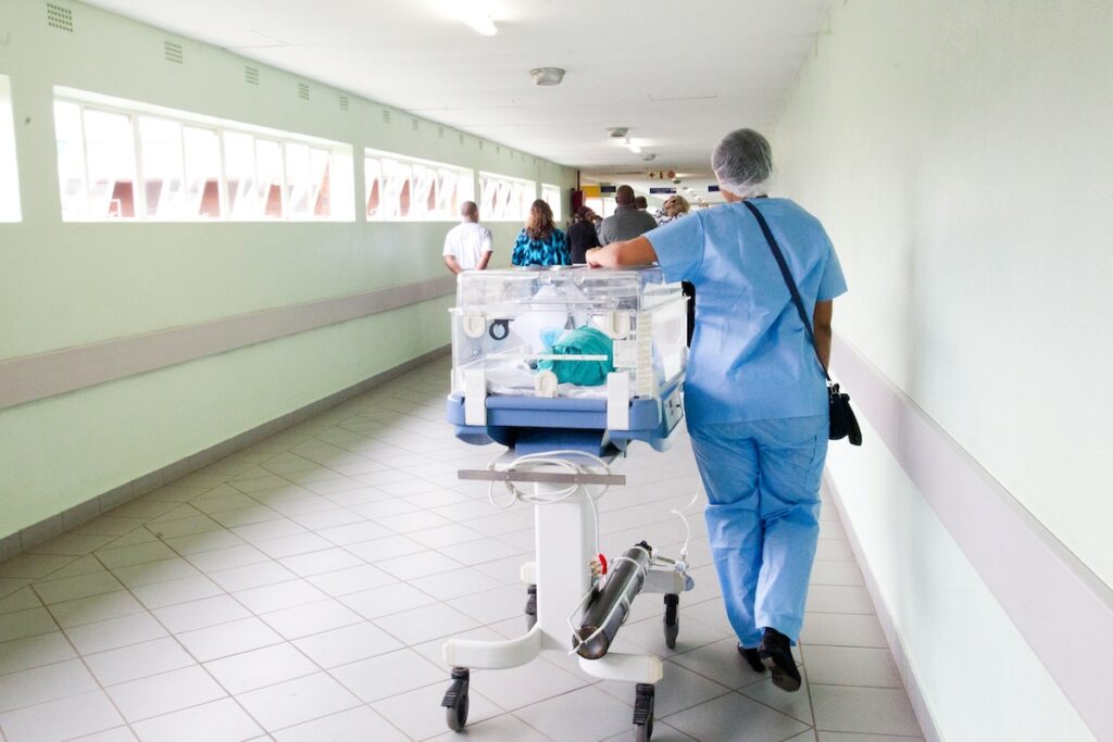 medical professions wheel a gurney down a hallway