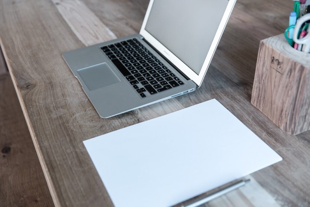 desk with laptop and notepaper