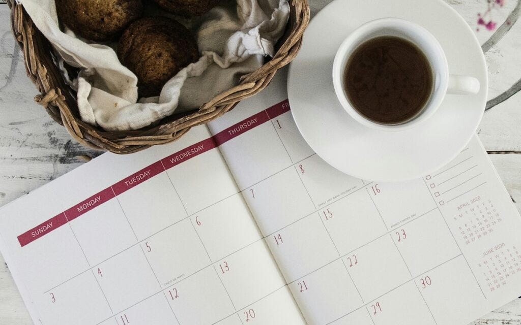 flat lay of a calendar with a cup of coffee