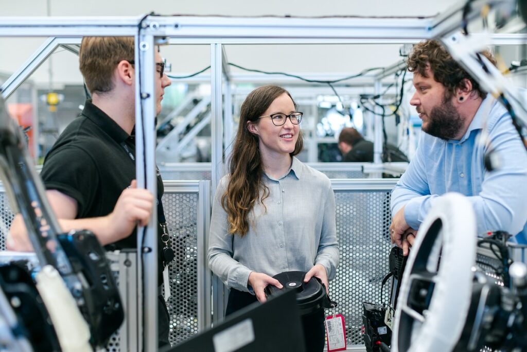 female engineering student confers with two male students