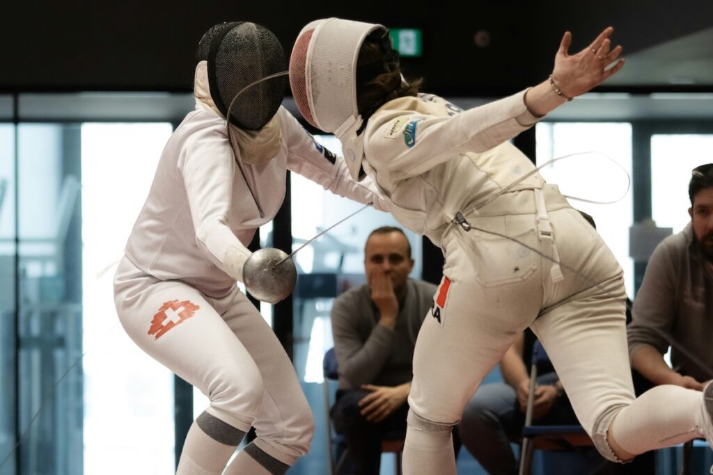 opponents face off in a fencing match