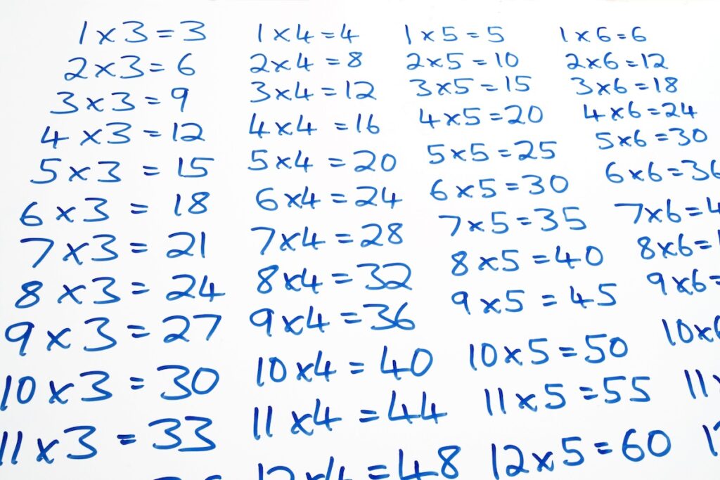Times tables written on a whiteboard.