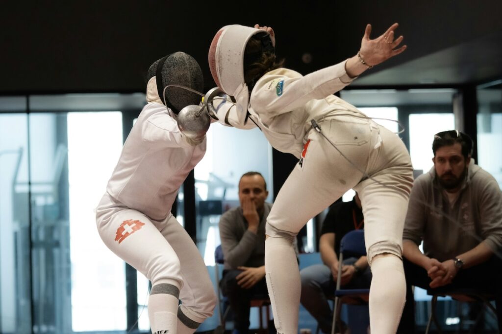 opponents face off in a fencing match