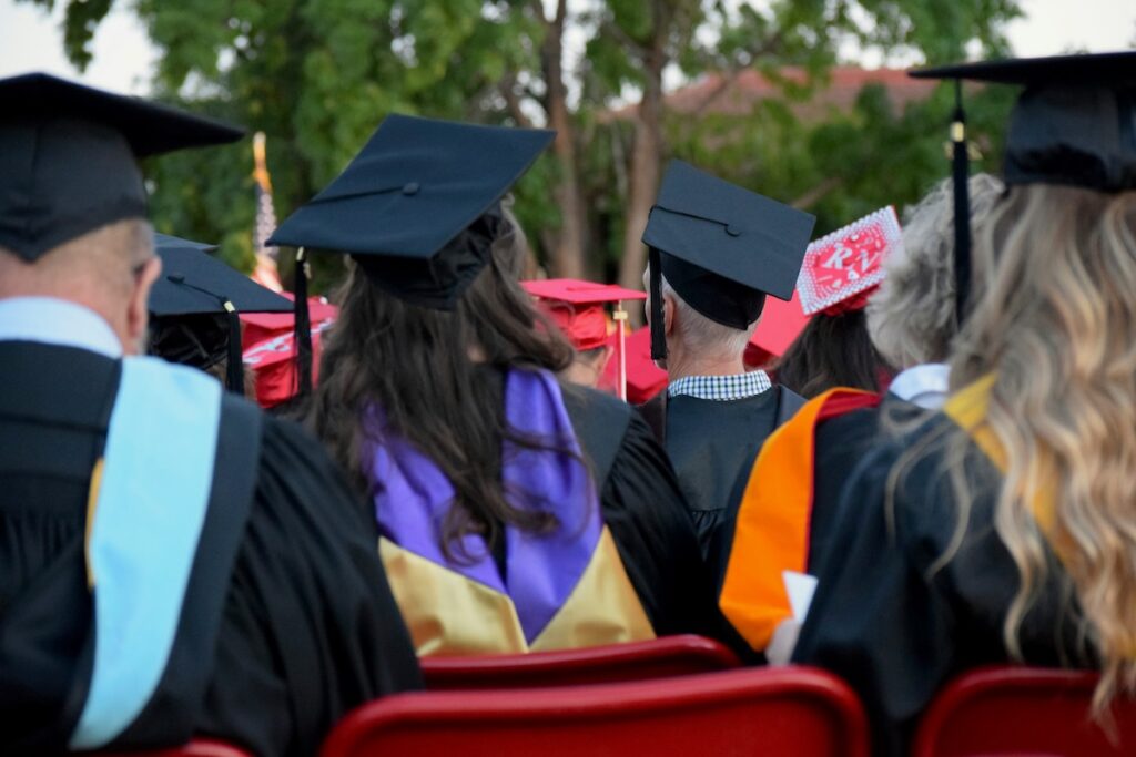backs of the heads of graduates in caps and gowns