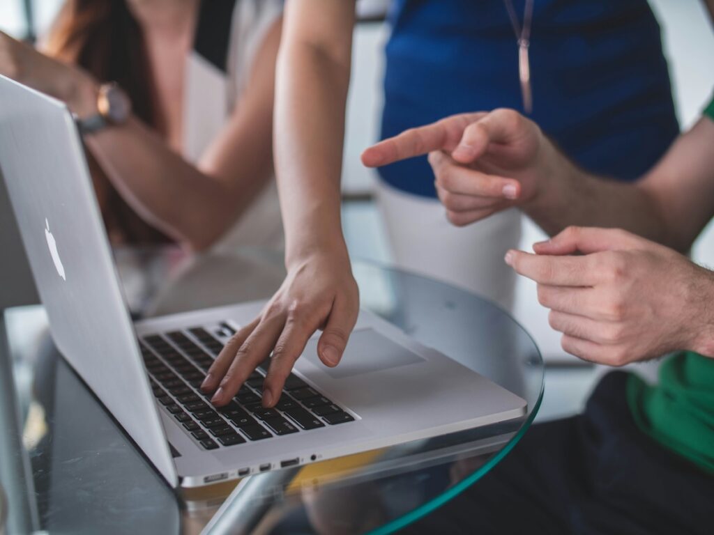 three people crowded around laptop