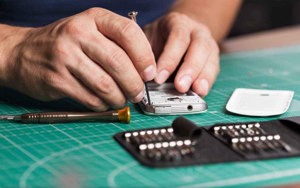 Man repairing broken smartphone, close up photo.