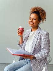 A women with cup of coffe and red book