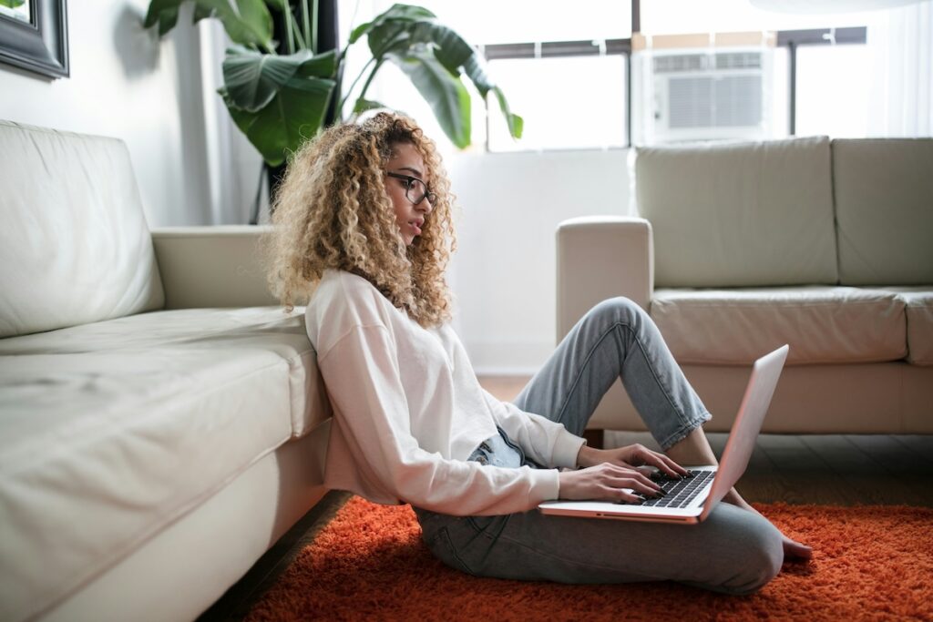 woman studying on laptop while sitting on the floor