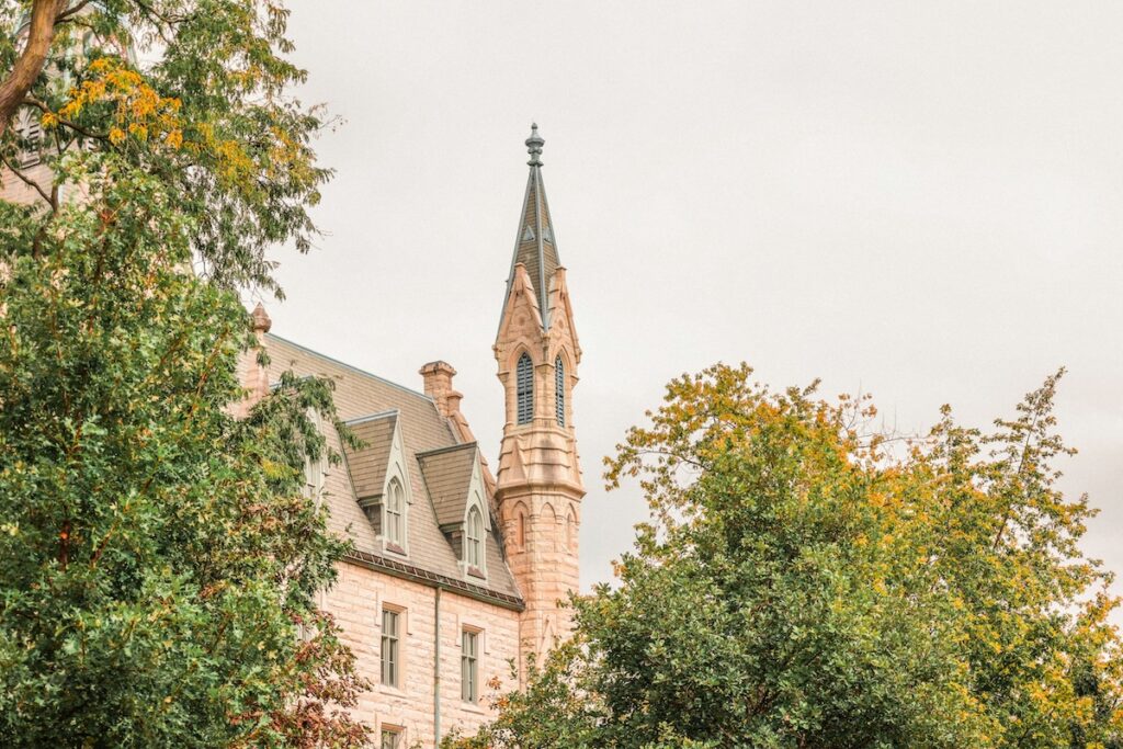 spire on historic building seen through trees